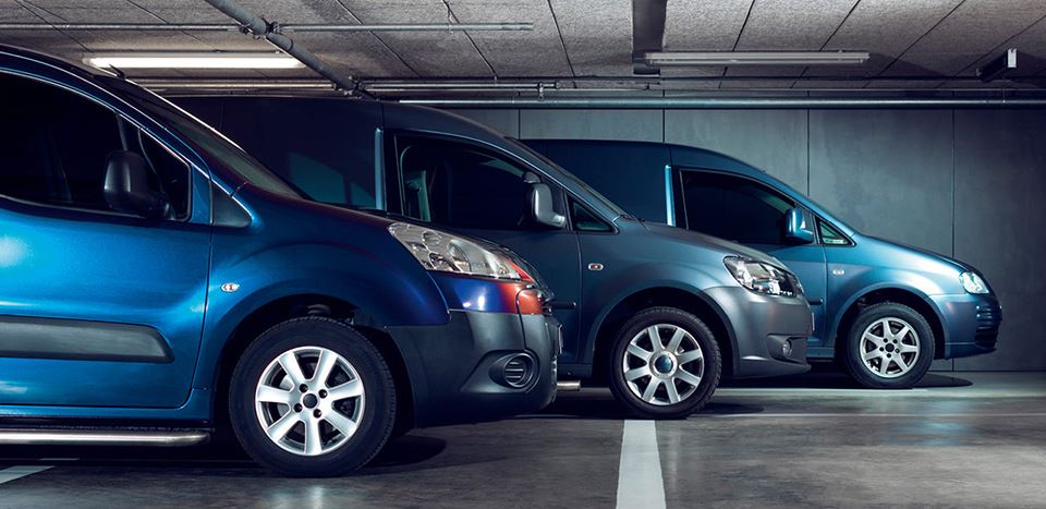 3 nyfolierade transportbilar i ett garage